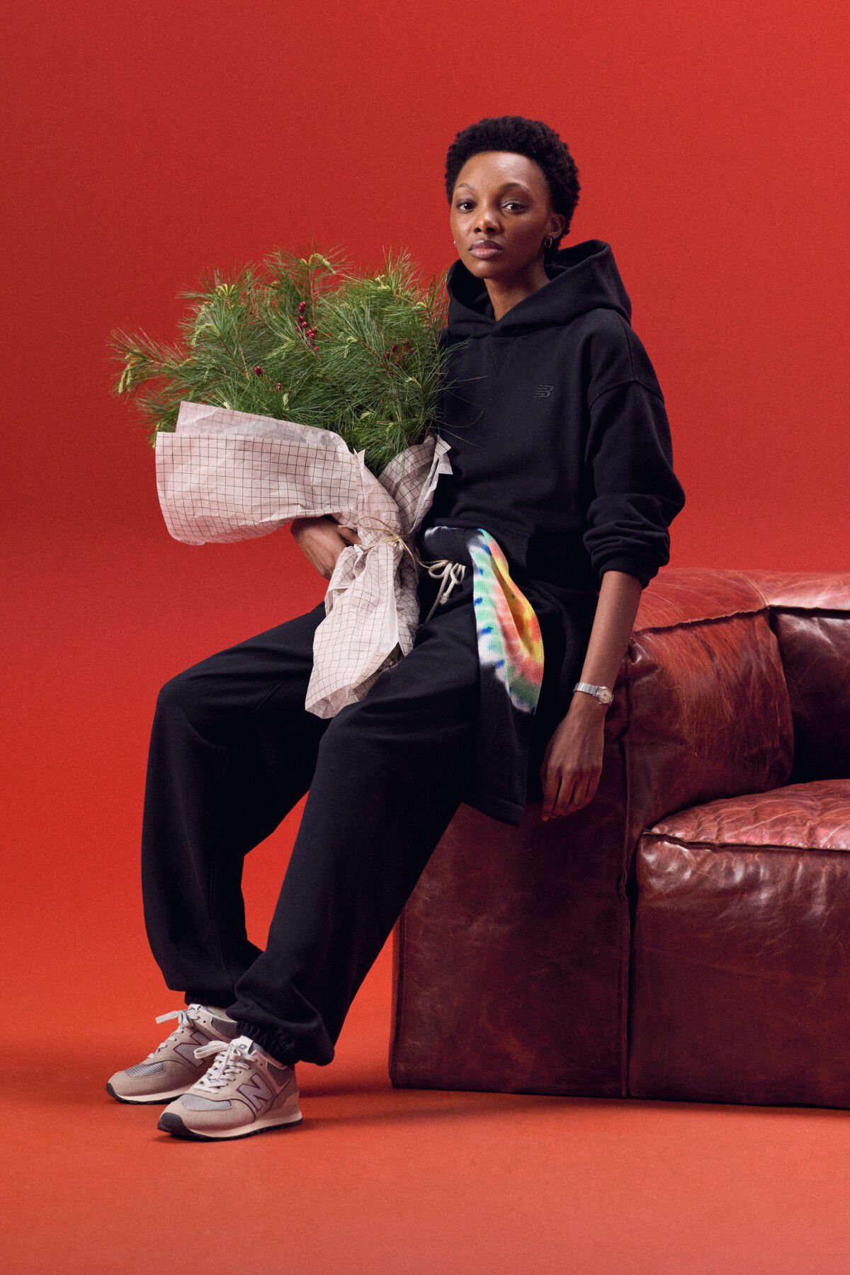 Woman wearing a white hat and brown jacket on a grey background.