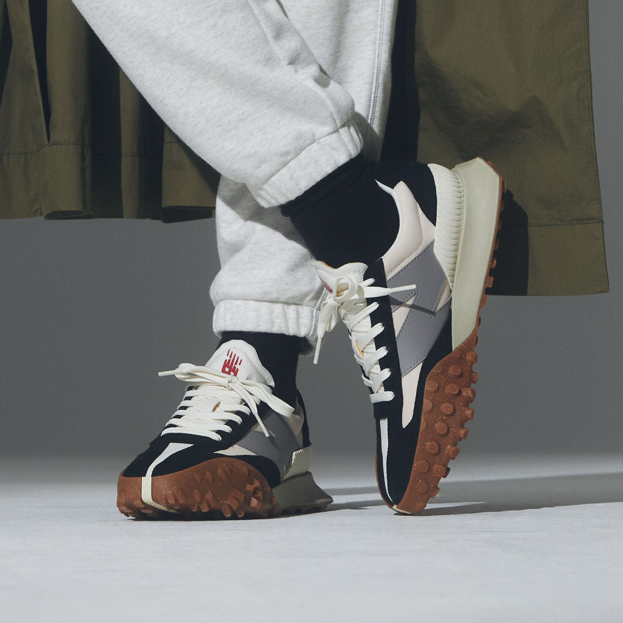 Model wearing the black and white shoes showing them from the ankle down.