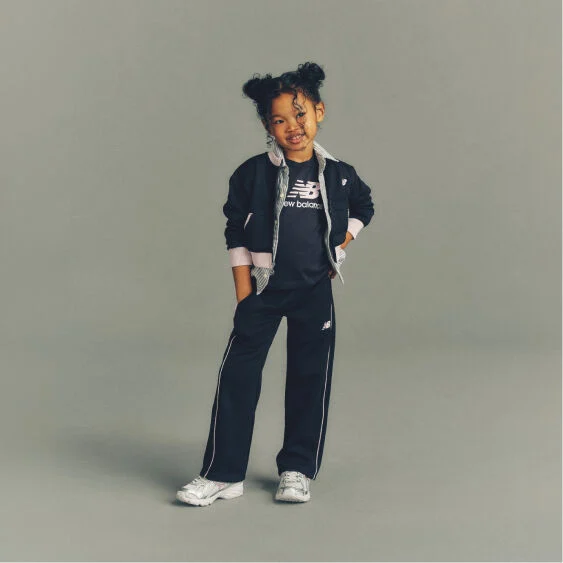 Child wearing New Balance clothes and shoes in a studio